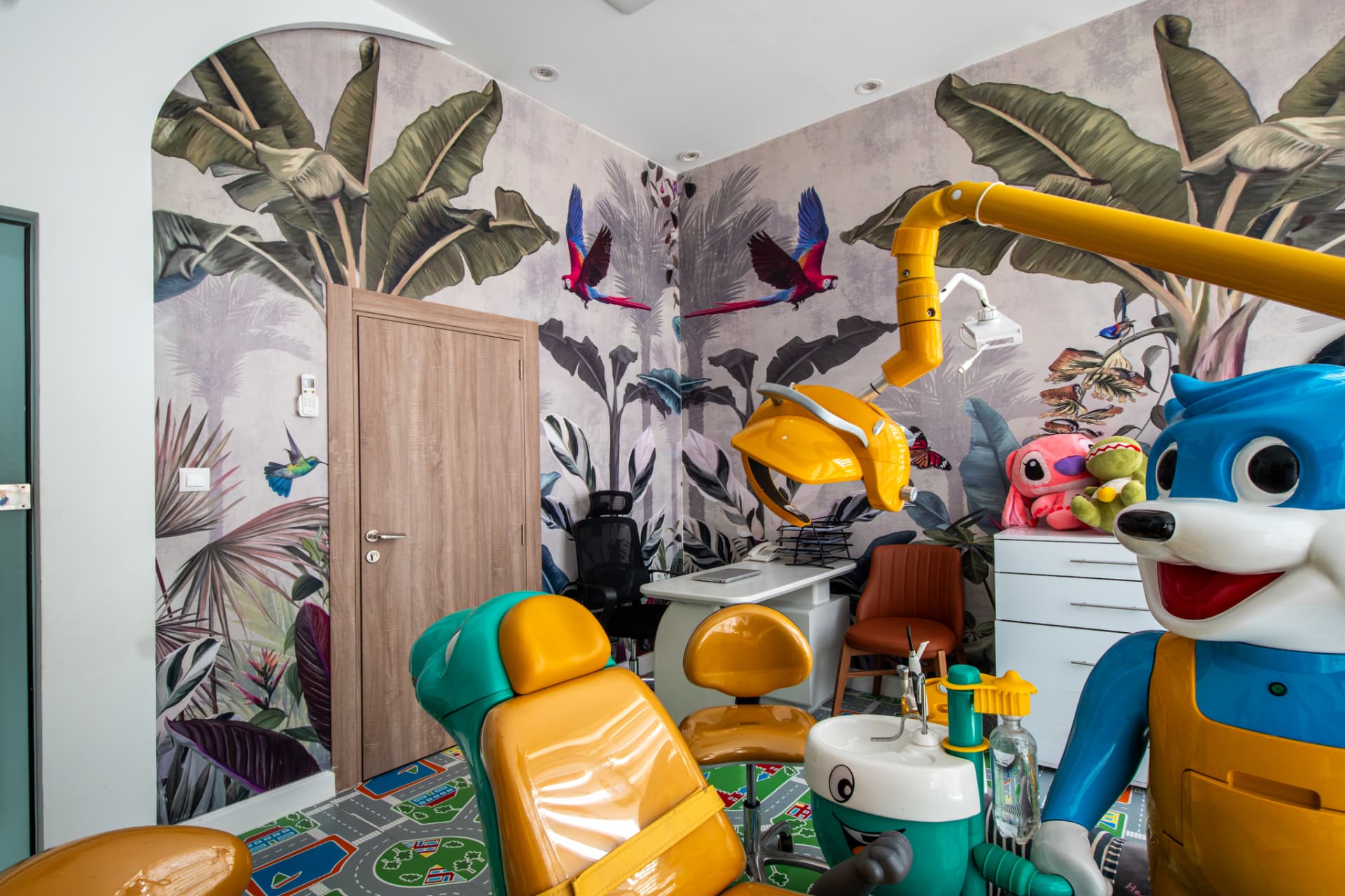 Cabinet pédiatrique avec fresque tropicale et fauteuil coloré